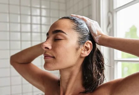 Woman massaging Lunavo rosemary shampoo into her scalp