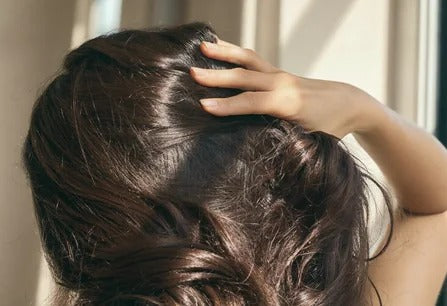 Fingers running through thick, healthy hair