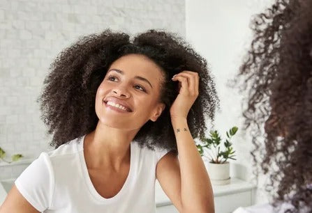 Woman checking her fuller hairline in the mirror