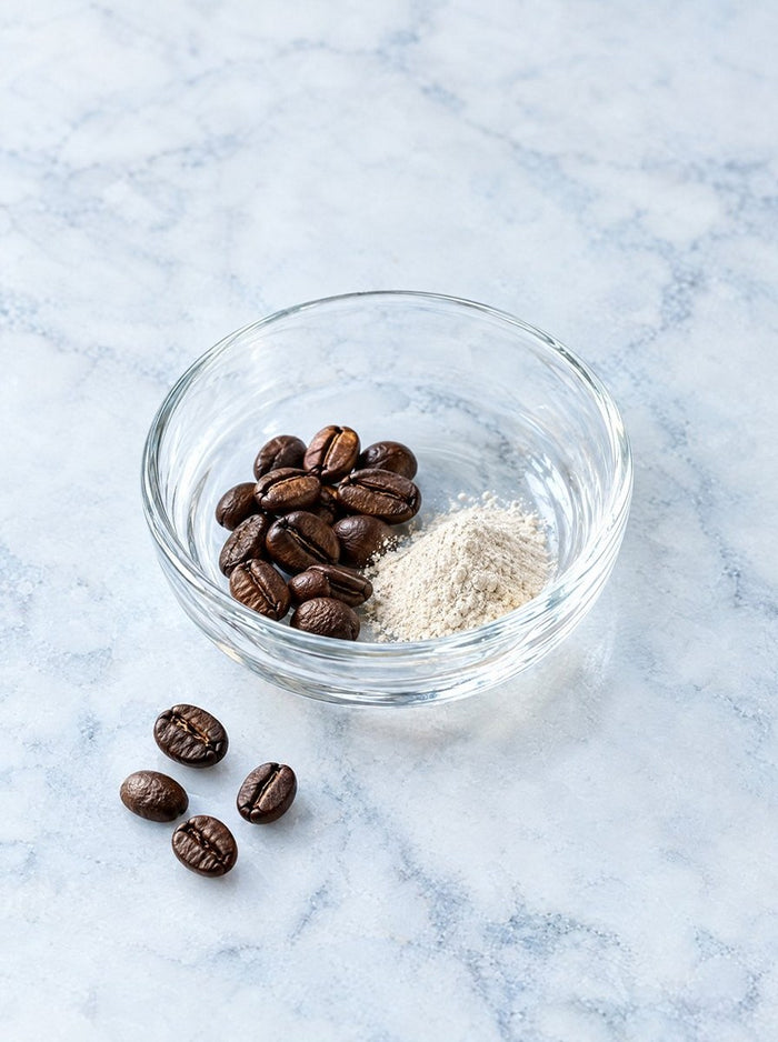 Coffee beans and caffeine powder in a glass dish